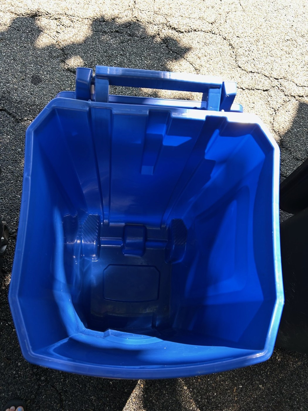 The same recycling bin after cleaning, bright blue and spotless